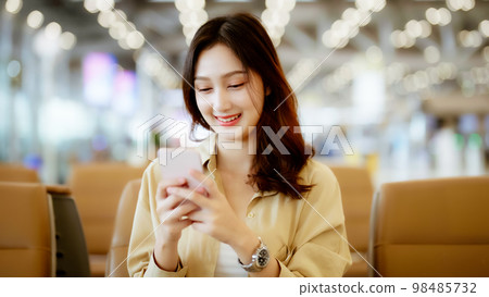 Asian woman waiting for departure at the airport on vacation holiday Asian woman waiting for departure at the airport on vacation holiday 98485732