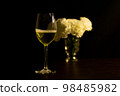 Festive party concept, Glass of champagne with peony in vase on wood table over black background 98485982