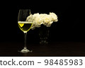 Festive party concept, Glass of champagne with peony in vase on wood table over black background 98485983