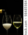 Champagne with party concept, Pour champagne from bottle into glass on black background 98485984