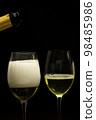 Champagne with party concept, Pour champagne from bottle into glass on black background 98485986