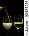 Champagne with party concept, Pour champagne from bottle into glass on black background 98485988