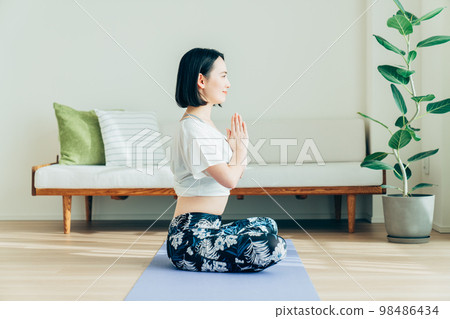Young woman doing yoga in the living room Young woman doing yoga in the living room 98486434