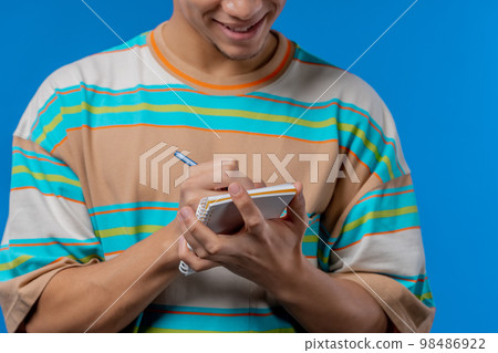 Hands of man writing notes in planner with pen. Student guy writes future plans and to-do list in Hands of man writing notes in planner with pen. Student guy writes future plans and to-do list in 98486922