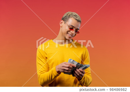 Satisfied man counting USD currency. Young millenial guy or student counts money - dollars banknotes 98486982