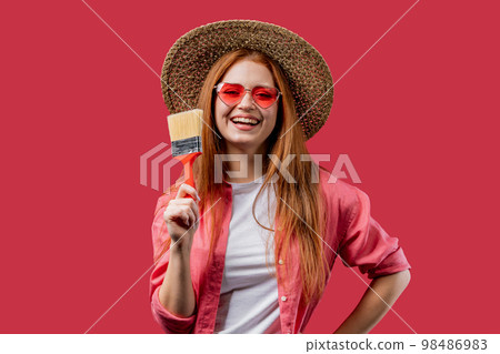 Young woman artist with brush on viva magenta or pink background. Creative person, fantasy, idea 98486983