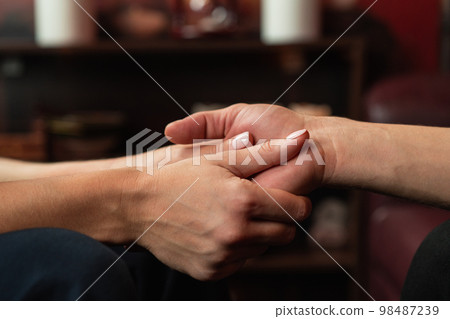 The therapist holds the hands of his patient during therapy. The concept of psychological assistance The therapist holds the hands of his patient during therapy. The concept of psychological assistance 98487239
