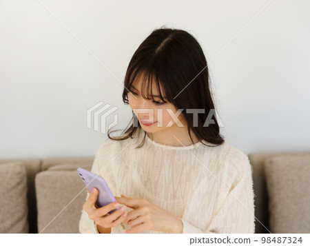 Woman operating a smartphone 98487324