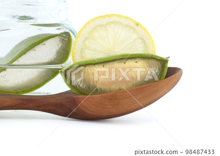 Aloe Vera in wooden spoon and lemon slices on white background Aloe Vera in wooden spoon and lemon slices on white background 98487433
