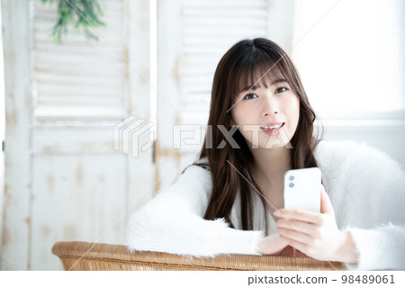 A young woman using a smartphone A young woman using a smartphone 98489061