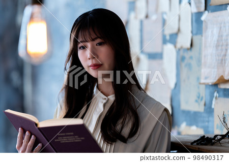 Young woman reading in a chic room Young woman reading in a chic room 98490317