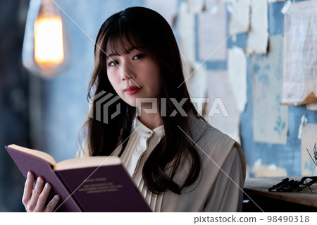 Young woman reading in a chic room Young woman reading in a chic room 98490318