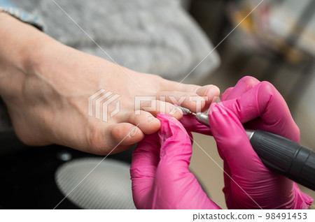 The master makes hardware pedicures to the client. Cuticle treatment.  98491453