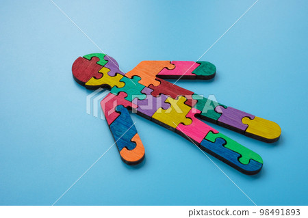 Figure of a man made of multi-colored puzzle pieces. Autism or neurodiversity concept. 98491893