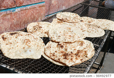 Stack of homemade pita bread for sale at a street food market, Iran. Fresh pitta flatbread 98492977