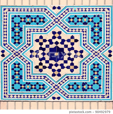 Detail of persian mosaic wall with geometric ornament of blue, dark blue and yellow color, Iran 98492979