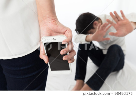 一個男人害怕一個拿著智能手機的女人。 98493175