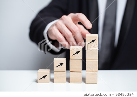 Wooden cubes with black arrows, business growth success thumb up concept, businessman thumb up 98493384
