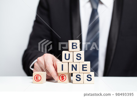 Wooden cubes with word business, business growth success goal concept, businessman holding block Wooden cubes with word business, business growth success goal concept, businessman holding block 98493395