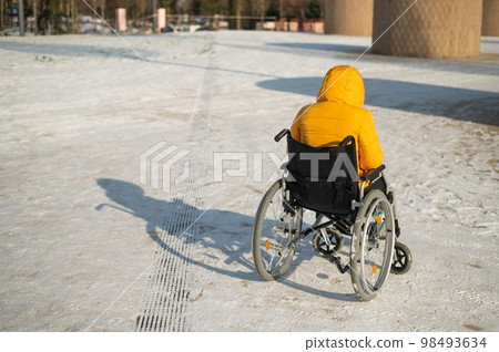 Homeless woman sitting in wheelchair in winter. Homeless woman sitting in wheelchair in winter. 98493634