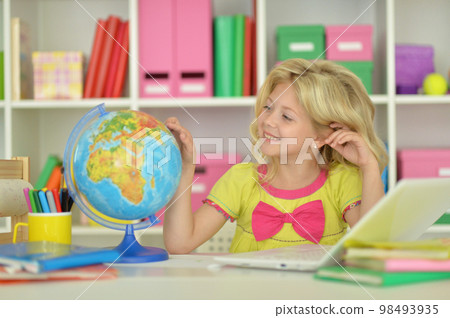 girl studying with a globe at the table 98493935