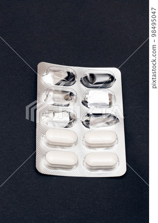 Packing pills on a gray background close up 98495047