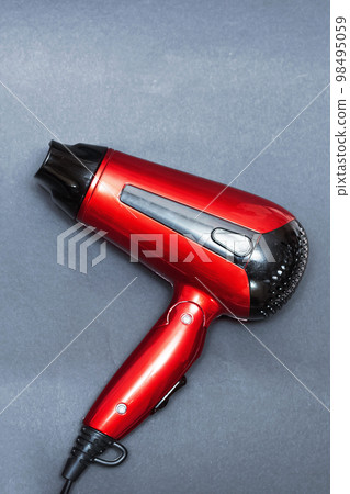 Red hair dryer on a gray background 98495059