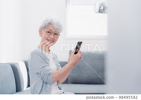 微笑著操作智能手機的高級女性 微笑著操作智能手機的高級女性 98495582