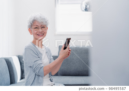微笑著操作智能手機的高級女性 微笑著操作智能手機的高級女性 98495587