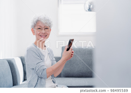 微笑著操作智能手機的高級女性 微笑著操作智能手機的高級女性 98495589