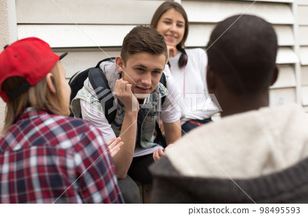 group of modern teens chatting in the yard group of modern teens chatting in the yard 98495593