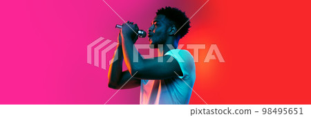 Singer. Horizontal banner with portrait of young african man over background in neon light. Music, beauty, fashion, youth concept. 98495651