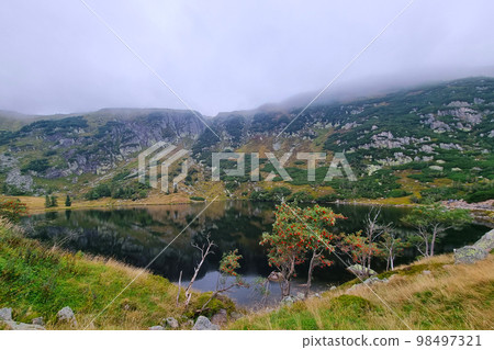 A picturesque mountain lake in a misty autumn morning. 98497321