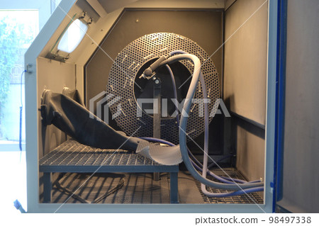 Inside Shot blasting machine. Open machine for Shot blasting of objects. Industrial machine, rubber gloves Inside Shot blasting machine. Open machine for Shot blasting of objects. Industrial machine, rubber gloves 98497338
