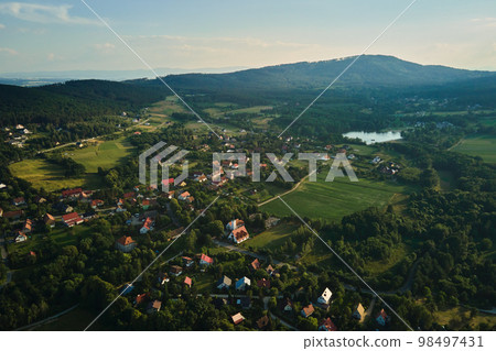 Overhead view of beautiful suburb landscape, Aerial view of countryside area with village and green fields near mountains 98497431