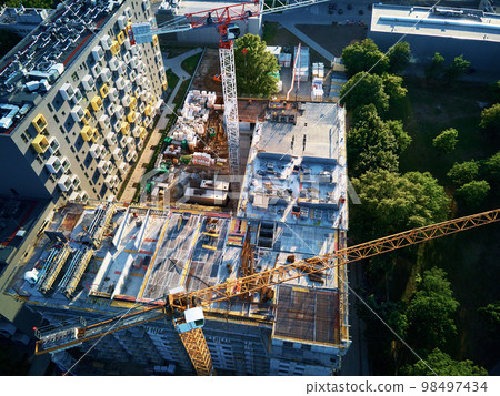 Aerial view of construction site with residential building under construction. Tower crane on construction site in city 98497434
