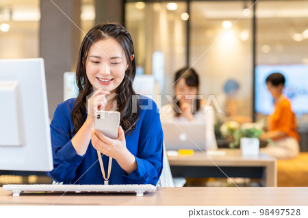 Business woman who uses a smartphone in the office Photo cooperation: WEEK Shibadaimon (Sun Frontier Fudousan) 98497528
