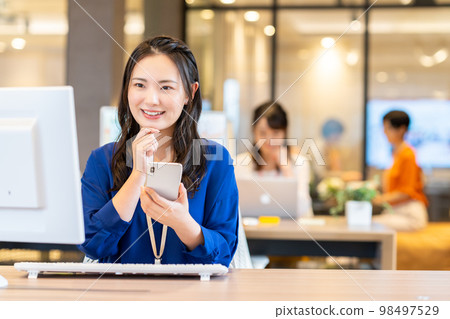 Business woman who uses a smartphone in the office Photo cooperation: WEEK Shibadaimon (Sun Frontier Fudousan) 98497529