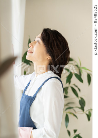 middle woman cleaning windows middle woman cleaning windows 98498525