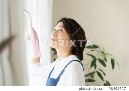 middle woman cleaning windows 98498527