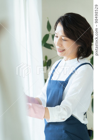 middle woman cleaning windows 98498529
