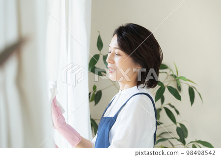 middle woman cleaning windows 98498542