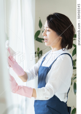 middle woman cleaning windows middle woman cleaning windows 98498545