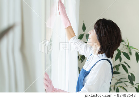 middle woman cleaning windows 98498548