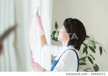 middle woman cleaning windows middle woman cleaning windows 98498551