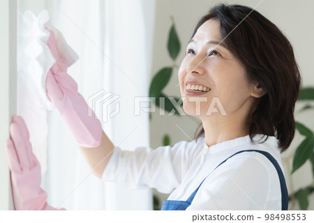 middle woman cleaning windows middle woman cleaning windows 98498553