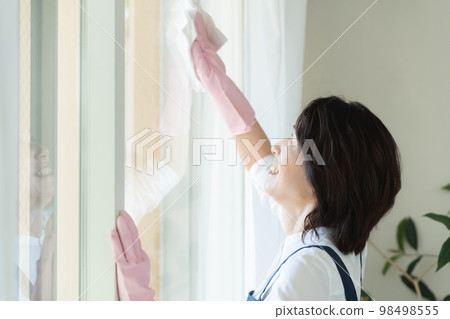middle woman cleaning windows middle woman cleaning windows 98498555