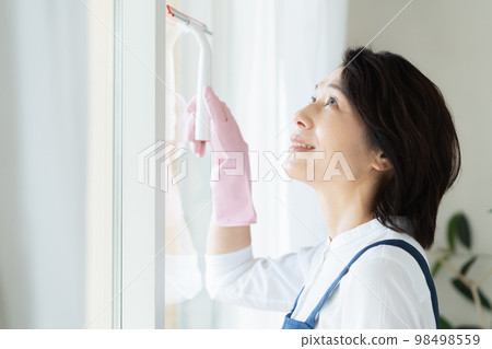 middle woman cleaning windows middle woman cleaning windows 98498559