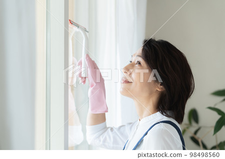 middle woman cleaning windows middle woman cleaning windows 98498560