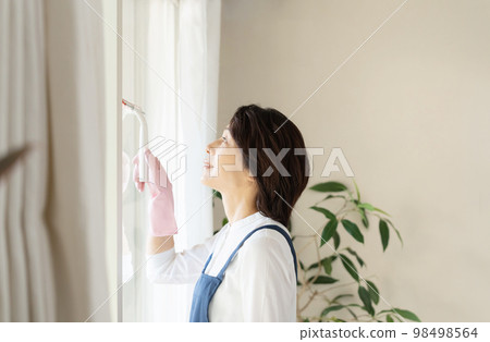 middle woman cleaning windows middle woman cleaning windows 98498564